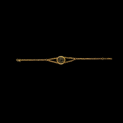 Gold bracelet with a circular clasp on a black background